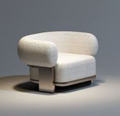 a white chair sitting on top of a floor next to a gray wall in front of it