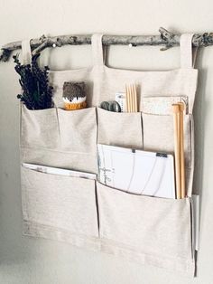 a bag hanging on the wall with some utensils and other items in it