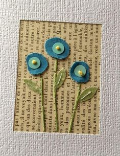 two blue flowers on top of a piece of paper