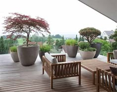 an outdoor patio with potted plants and wooden furniture on the outside decking area