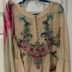 Embroidered Net Kameez, Silk Trouser, Chiffon Dupatta Sleeves: 22” Shoulder: 15” Length: 37” Pit To Pit: 20” Trousers: Length: 36” Rise: 14” Inseam: 26” Waist: 20” Fitted Cream Salwar Kameez With Sheer Dupatta, Fitted Beige Anarkali Set With Dupatta, Cream Salwar Kameez With Sheer Dupatta And Long Sleeves, Cream Salwar Kameez With Dabka Work For Party, Beige Bollywood Salwar Kameez For Transitional Seasons, Red Anarkali Churidar With Floral Embroidery, Bollywood Style Beige Salwar Kameez For Transitional Season, Fitted Designer Beige Anarkali Set, Bollywood Style Dress With Multicolor Embroidery And Sheer Dupatta