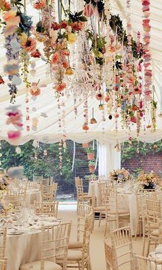 the inside of a marquee decorated with flowers and chandeliers