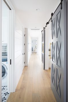 an open door leading to a washer and dryer in a room with wood floors