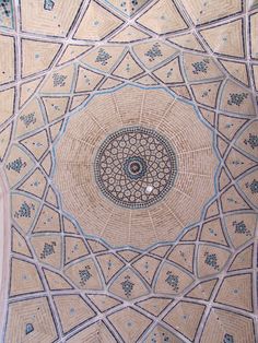 an intricately designed ceiling with blue and white designs on the top, in a building