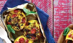 two baskets filled with food sitting on top of a blue cloth next to each other