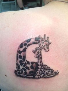 a giraffe and her baby are depicted on the back of a woman's shoulder