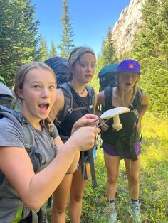 three girls hiking in the woods with backpacks