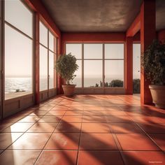 an empty room with large windows and potted plants on the floor, overlooking the ocean