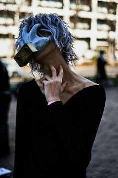 a woman with blue hair is covering her face