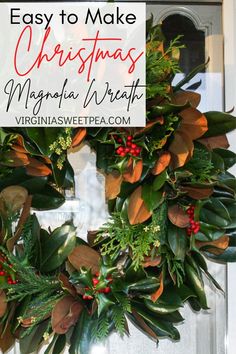 a christmas wreath hanging on the front door with holly and red berries, greenery and evergreen leaves