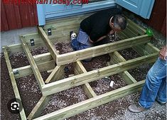 two men working on a wooden bench in front of a door