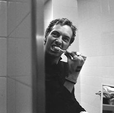 a man brushing his teeth in the bathroom