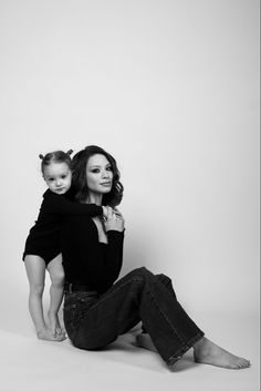 a woman sitting on the ground holding a child