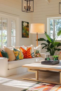 a living room filled with lots of furniture and pillows on top of a white couch