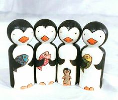 a group of penguin figurines are standing next to each other on a white surface