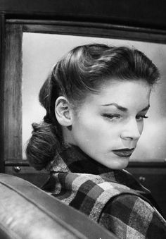 a black and white photo of a woman looking at something