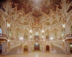 an ornately decorated building with stairs and chandeliers