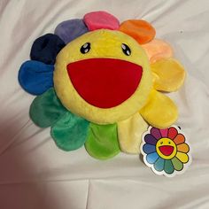 a yellow stuffed animal with multi colored flowers on it