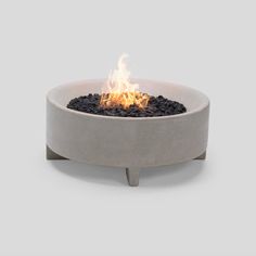 a concrete fire pit with flames burning in it