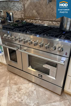 a stainless steel stove and oven in a kitchen with tile flooring on the walls