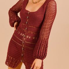 a woman wearing a red crochet knit dress with long sleeves and an open front