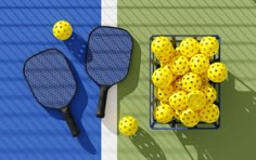 two tennis rackets are next to a basket of yellow balls on a green and blue background