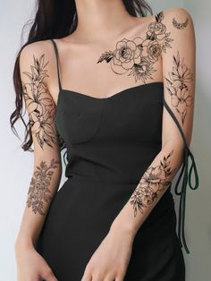 a woman with tattoos on her arm and shoulder is posing for the camera while wearing a black dress