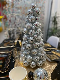 a christmas tree made out of disco balls on top of a table with other decorations