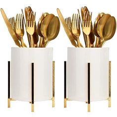 two white vases with gold forks and spoons in them, one is filled with utensils