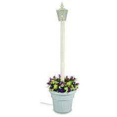 a white light pole with flowers in it