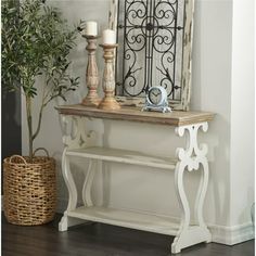 a white console table with two candles and a potted plant