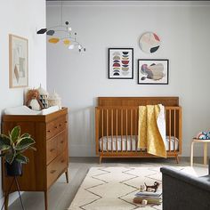 a baby's room with a crib, dresser and rug in the foreground