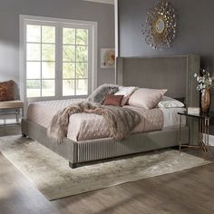 a large bed sitting on top of a wooden floor next to a chair and table