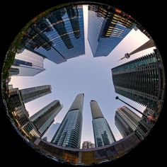 the view from below looking up at tall buildings in a city with skyscrapers on either side