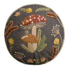 an embroidered mushroom pillow on a white background