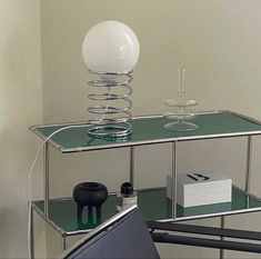 a glass shelf with a white ball on top and some other items sitting on it