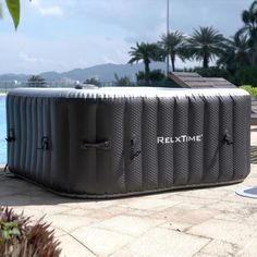 an inflatable hot tub sitting next to a swimming pool with the words relaxtime written on it