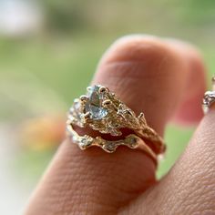 a close up of a person's hand with two rings on their fingers and one is wearing an engagement ring