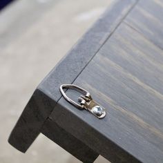 a close up of a wooden table with a pair of scissors on the edge of it