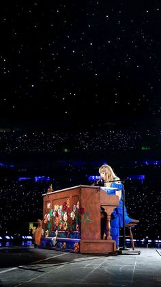 a woman standing at a podium on top of a stage