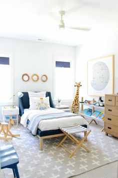 a child's bedroom with a giraffe on the wall