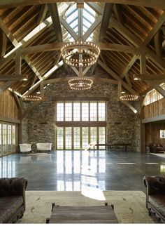 a large open room with two couches and a chandelier hanging from the ceiling