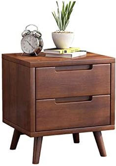 an alarm clock sitting on top of a wooden nightstand