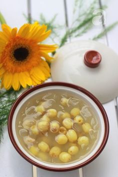 a bowl filled with soup next to a yellow flower