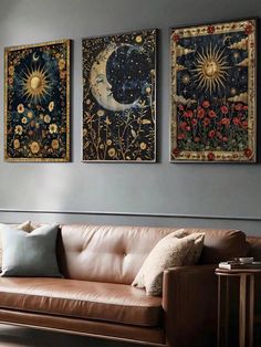 three paintings hang on the wall above a couch