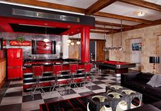 a living room filled with furniture and a pool table in the middle of it on top of a checkered floor