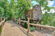 a wooden structure in the middle of a forest with lots of trees and bushes around it