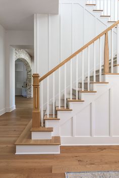 a white staircase with wooden handrails in a house