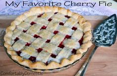 a pie sitting on top of a wooden table next to a spatula and knife