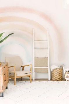 a room with a ladder, chair and potted plant on the floor in front of a painted wall